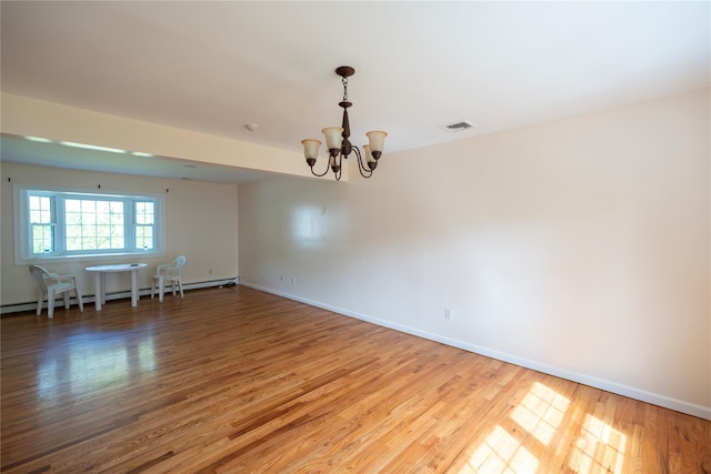 21 Pine Cone St, Middle Island, NY 11953 - spare room with a baseboard heating unit, a chandelier, wood finished floors, and baseboards