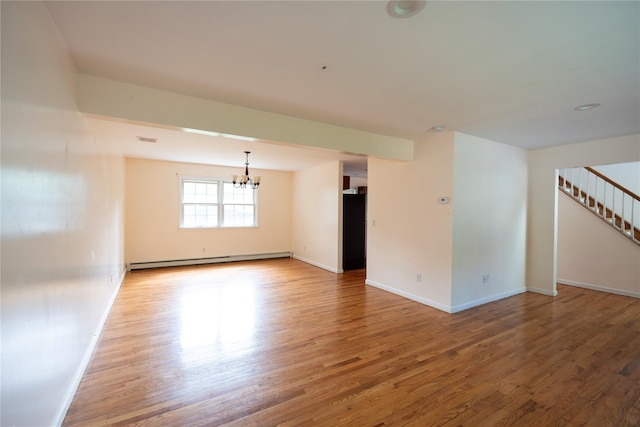 21 Pine Cone St, Middle Island, NY 11953 - spare room with a baseboard heating unit, a chandelier, wood finished floors, and baseboards