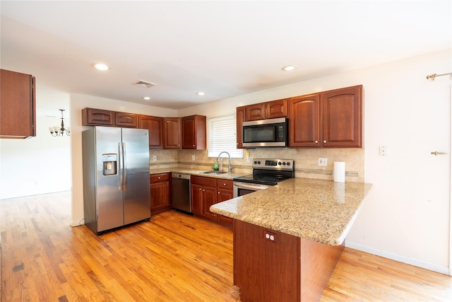 21 Pine Cone St, Middle Island, NY 11953 - kitchen with appliances with stainless steel finishes, a sink, a peninsula, light wood-style flooring, and recessed lighting