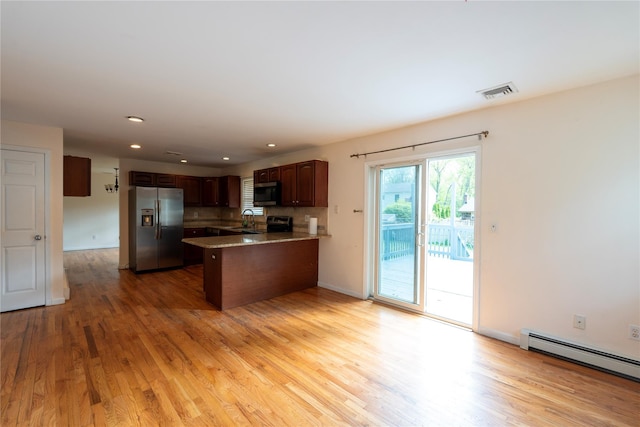 21 Pine Cone St, Middle Island, NY 11953 - kitchen featuring appliances with stainless steel finishes, a baseboard radiator, a sink, a peninsula, and light wood-type flooring