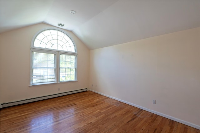 21 Pine Cone St, Middle Island, NY 11953 - bonus room with a baseboard heating unit, wood finished floors, vaulted ceiling, and baseboards