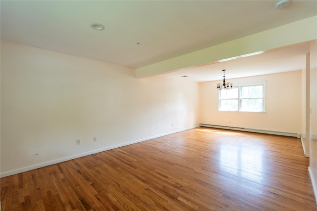 21 Pine Cone St, Middle Island, NY 11953 - spare room with a baseboard radiator, a chandelier, wood finished floors, and baseboards