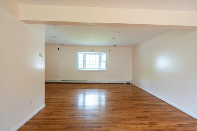 21 Pine Cone St, Middle Island, NY 11953 - unfurnished room featuring baseboards, wood finished floors, and a baseboard heating unit
