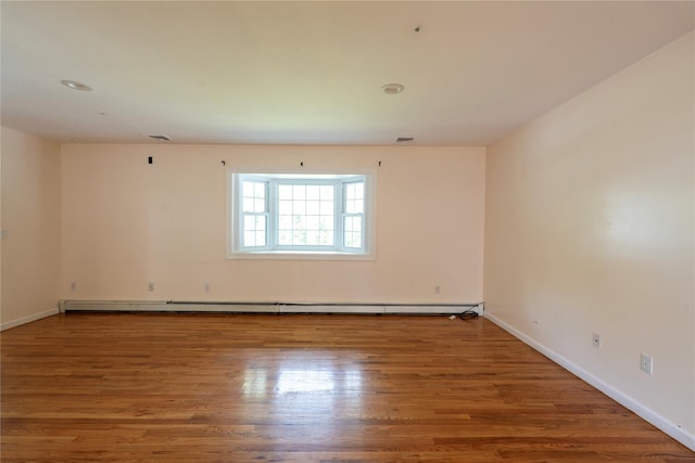 21 Pine Cone St, Middle Island, NY 11953 - spare room with baseboard heating, wood finished floors, and baseboards