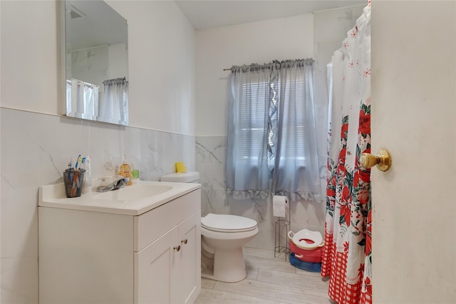 101 Baldwin Rd, Hempstead, NY 11550 - bathroom with tile walls, toilet, vanity, and wainscoting