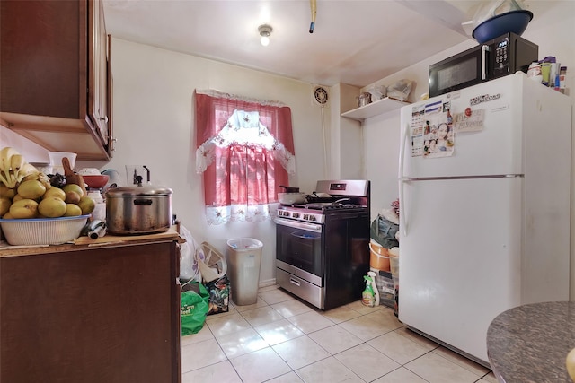 101 Baldwin Rd, Hempstead, NY 11550 - kitchen with gas stove, freestanding refrigerator, and light tile patterned floors