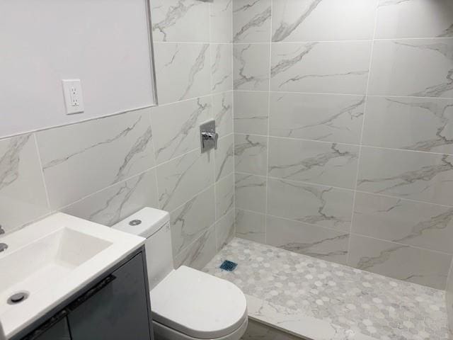 187-02 Foch Blvd, Saint Albans, NY 11412 - bathroom featuring a tile shower, toilet, vanity, and tile walls