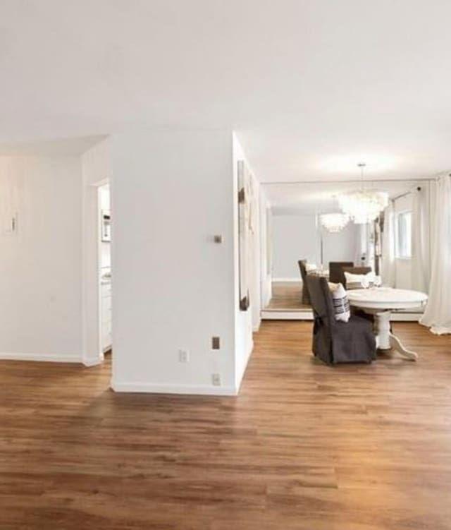 living area with wood finished floors, baseboards, and a chandelier