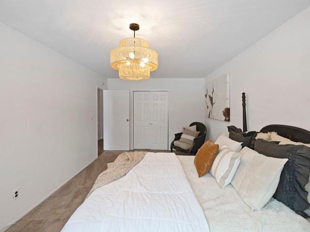 carpeted bedroom with a chandelier and a closet