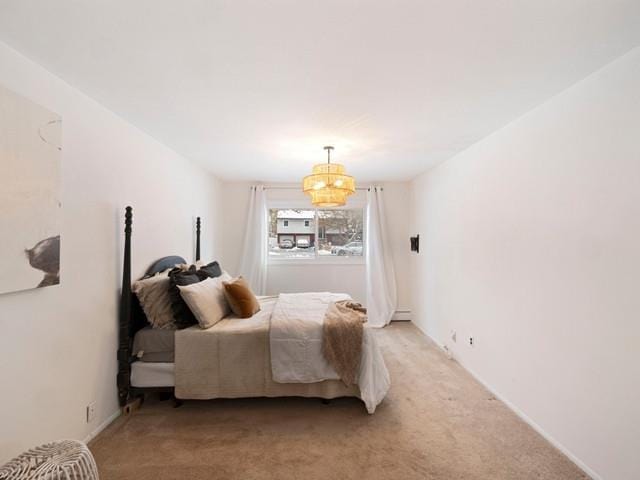 bedroom with light colored carpet and a chandelier