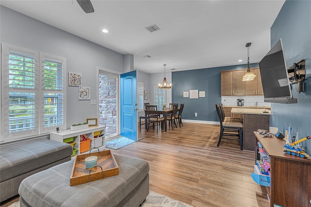 27 Lager Ln, Patchogue, NY 11772 - living room with light wood-style flooring, a chandelier, baseboards, recessed lighting, and a ceiling fan