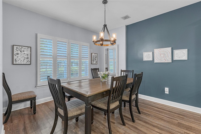 27 Lager Ln, Patchogue, NY 11772 - dining area featuring a chandelier, wood finished floors, and baseboards