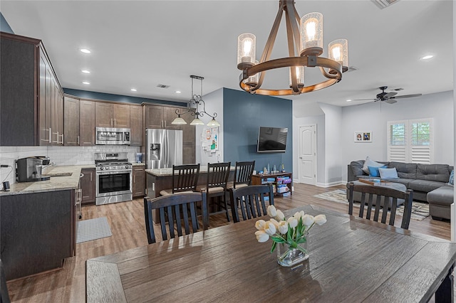 27 Lager Ln, Patchogue, NY 11772 - dining room with a chandelier, light wood-style flooring, a ceiling fan, recessed lighting, and baseboards