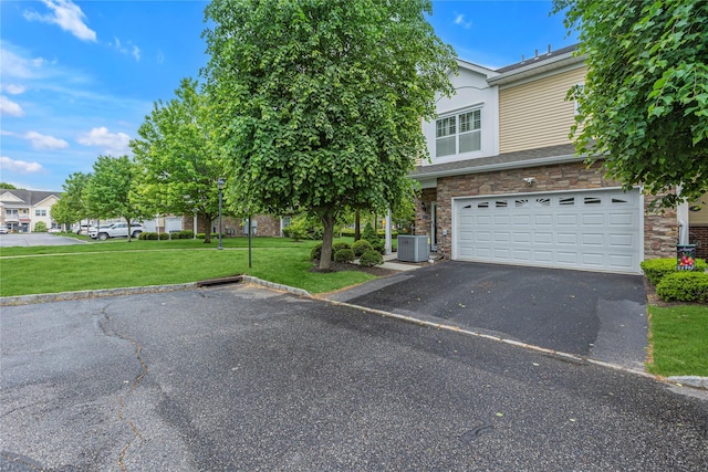 27 Lager Ln, Patchogue, NY 11772 - obstructed view of property featuring asphalt driveway, a garage, a front lawn, cooling unit, and stone siding