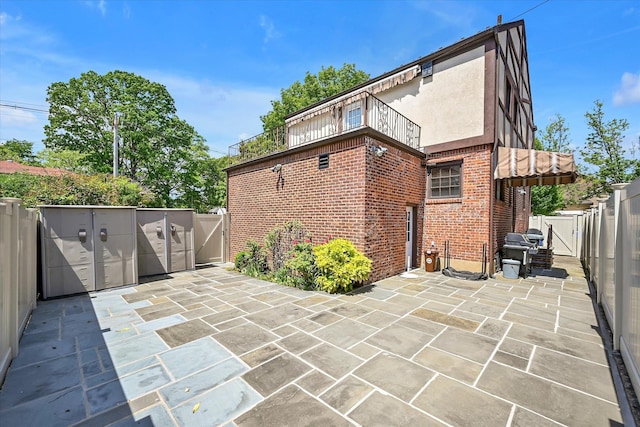 182-04 80th Dr, Jamaica Estates, NY 11432 - view of patio / terrace featuring a gate, a balcony, and a fenced backyard