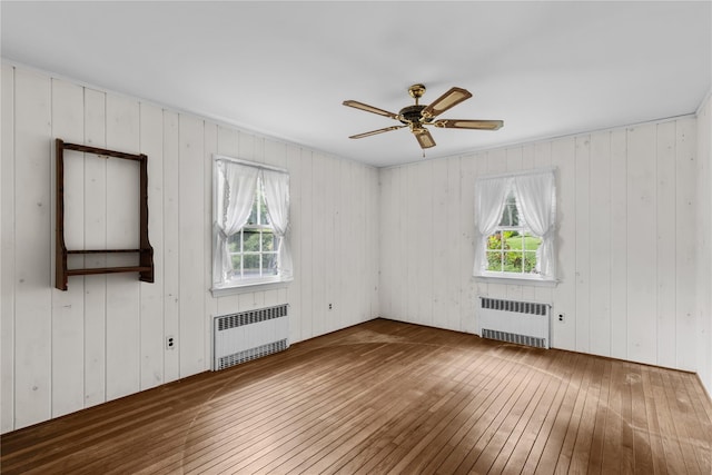 1015 Knollwood Ln, Mattituck, NY 11952 - unfurnished room with radiator heating unit, hardwood / wood-style floors, plenty of natural light, and wood walls