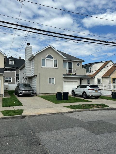 459 Monroe Blvd, Long Beach, NY 11561 - multi unit property featuring concrete driveway, stucco siding, and an attached garage