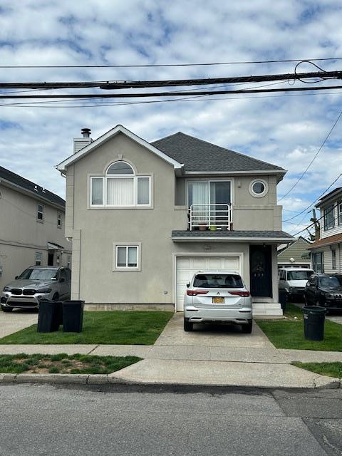 459 Monroe Blvd, Long Beach, NY 11561 - traditional home with driveway, a balcony, an attached garage, stucco siding, and a chimney