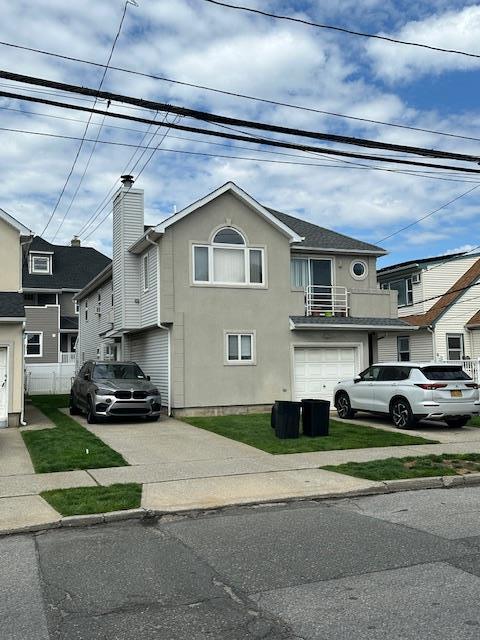 459 Monroe Blvd, Long Beach, NY 11561 - view of front facade with concrete driveway, a garage, and stucco siding