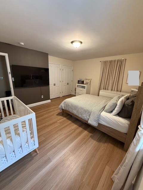 459 Monroe Blvd, Long Beach, NY 11561 - bedroom featuring wood finished floors, multiple closets, and baseboards