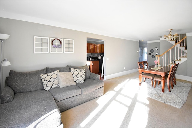 living room featuring a chandelier, light colored carpet, stairs, and baseboards