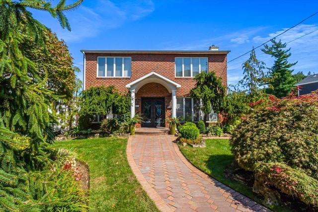 2957 214th Pl, Bayside, NY 11360 - view of front facade featuring french doors, brick siding, a chimney, and a front lawn