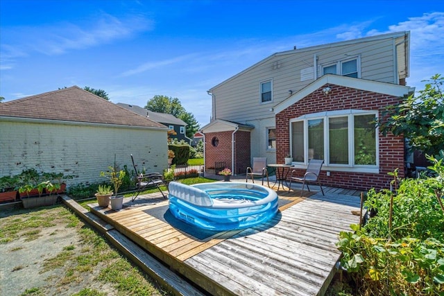 2957 214th Pl, Bayside, NY 11360 - back of house featuring a deck, brick siding, and an outdoor hot tub