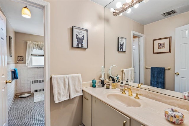 2957 214th Pl, Bayside, NY 11360 - bathroom with radiator, vanity, tile walls, tile patterned floors, and wainscoting