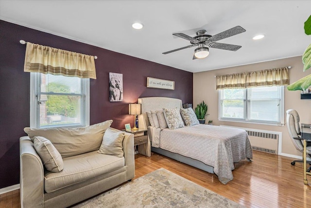 2957 214th Pl, Bayside, NY 11360 - bedroom with radiator heating unit, wood finished floors, baseboards, an accent wall, and recessed lighting