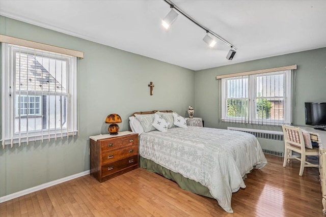2957 214th Pl, Bayside, NY 11360 - bedroom featuring track lighting, radiator heating unit, light wood finished floors, and baseboards