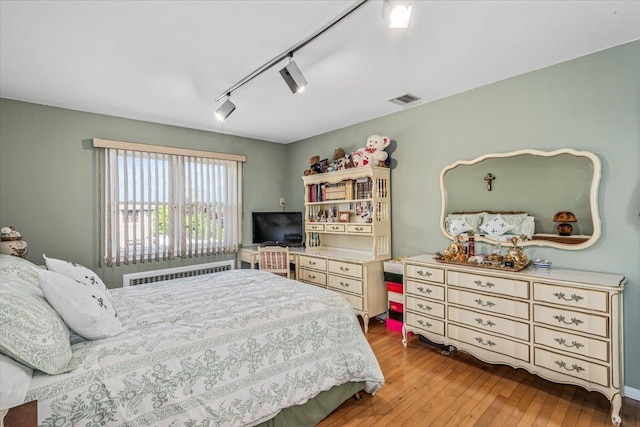 2957 214th Pl, Bayside, NY 11360 - bedroom with radiator, hardwood / wood-style floors, and rail lighting
