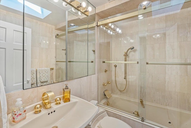 2957 214th Pl, Bayside, NY 11360 - bathroom with a skylight, tiled shower / bath combo, tile walls, toilet, and a sink