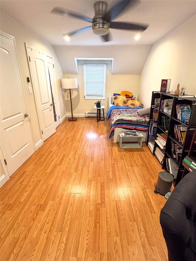 131 E Alhambra Ave, Lindenhurst, NY 11757 - bedroom with vaulted ceiling, light wood-style flooring, a ceiling fan, and a baseboard heating unit