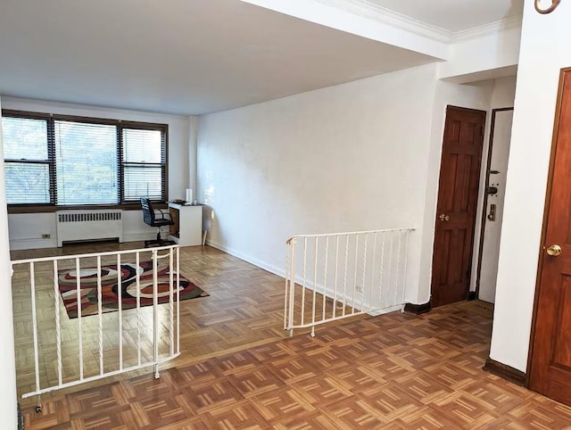 empty room with radiator heating unit, baseboards, and crown molding