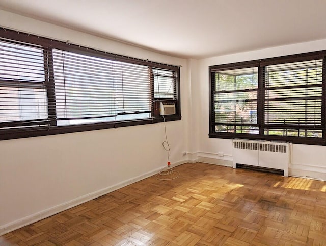 spare room featuring radiator heating unit, baseboards, and cooling unit