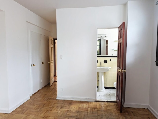 unfurnished bedroom with tile walls and connected bathroom