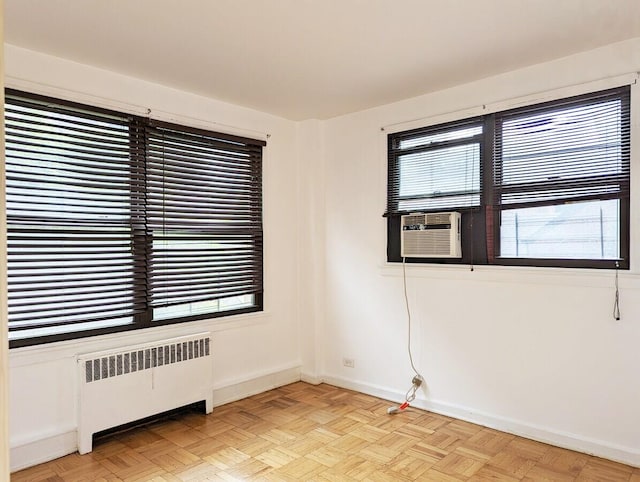 spare room featuring radiator, baseboards, and cooling unit