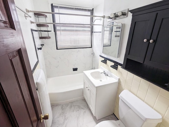 bathroom featuring toilet, vanity, marble look tile flooring, and shower / bath combination