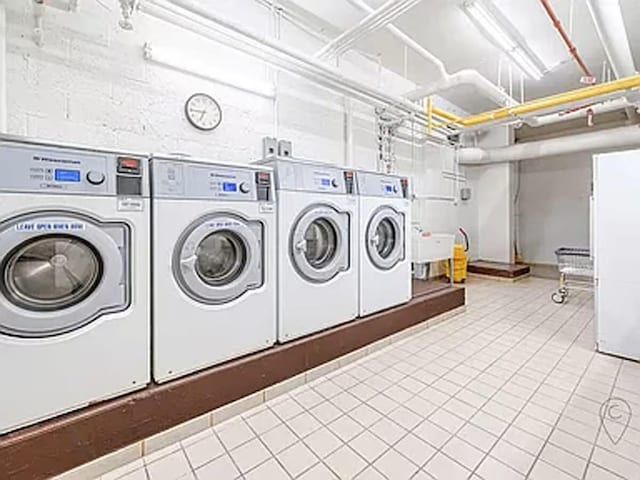 community laundry room with independent washer and dryer and tile patterned floors