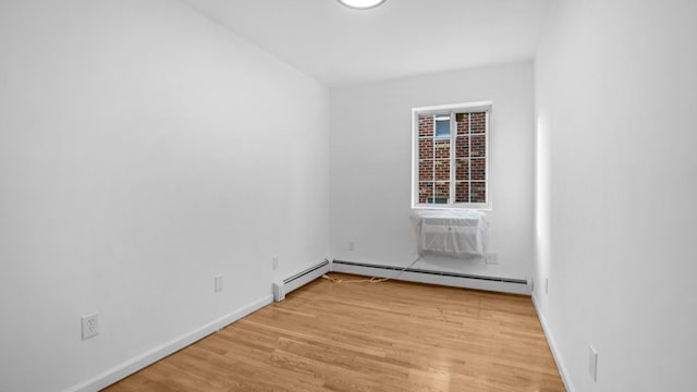 907 Clarence Ave, Bronx, NY 10465 - spare room with a baseboard radiator, light wood-style flooring, baseboards, and an AC wall unit