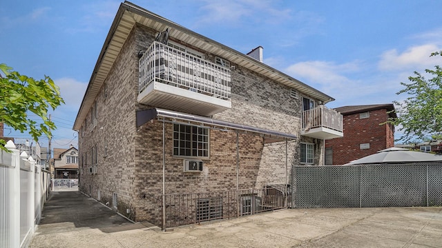 907 Clarence Ave, Bronx, NY 10465 - view of side of property with a balcony, fence, and brick siding
