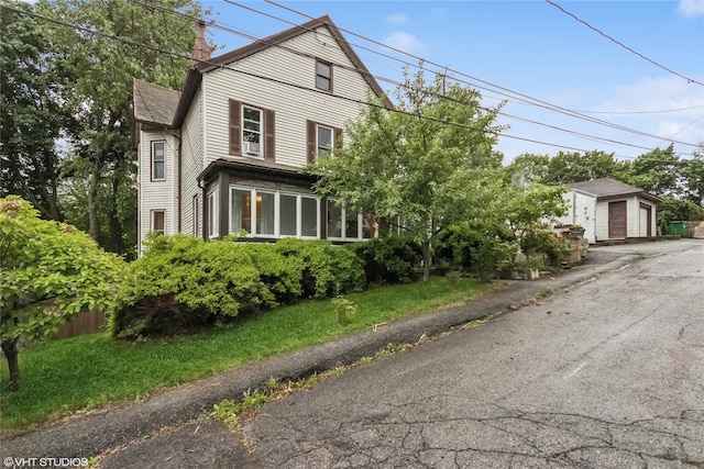 24 John St, Beacon, NY 12508 - view of front of house with an outdoor structure, a chimney, and a detached garage
