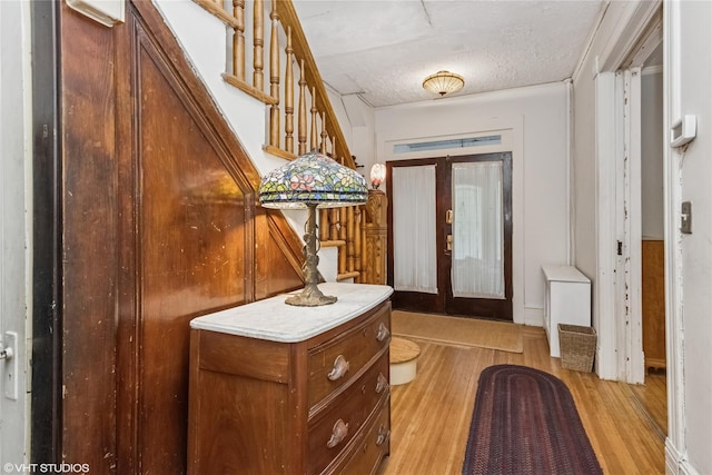 24 John St, Beacon, NY 12508 - foyer entrance with light wood-style flooring, stairway, and a textured ceiling