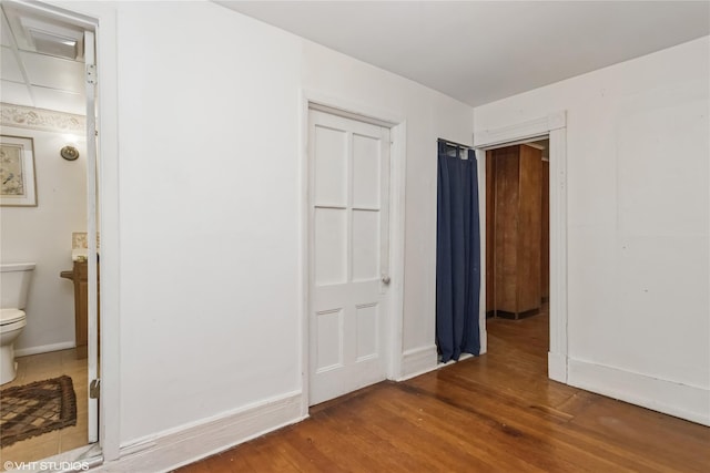 24 John St, Beacon, NY 12508 - unfurnished bedroom with wood finished floors, baseboards, and ensuite bathroom