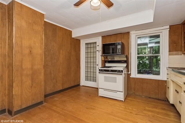 24 John St, Beacon, NY 12508 - kitchen with white range with gas stovetop, black microwave, light wood finished floors, brown cabinets, and ornamental molding