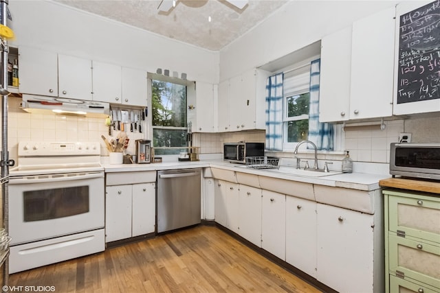 24 John St, Beacon, NY 12508 - kitchen featuring stainless steel appliances, light countertops, decorative backsplash, and light wood-style floors