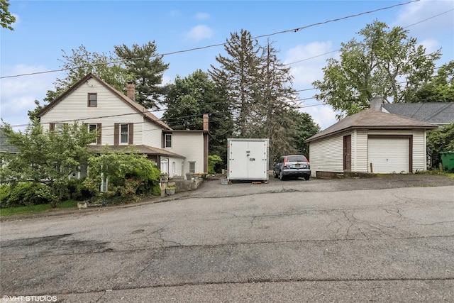 24 John St, Beacon, NY 12508 - view of property exterior with a chimney, a detached garage, and an outdoor structure