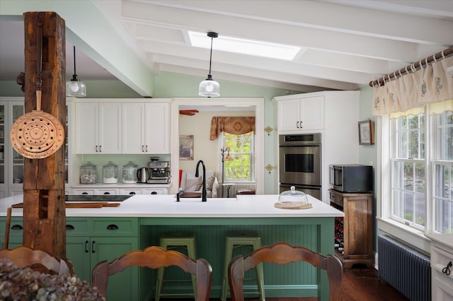 41 Granite Springs Rd, Granite Springs, NY 10527 - kitchen featuring radiator heating unit, a sink, stainless steel double oven, white cabinetry, and plenty of natural light