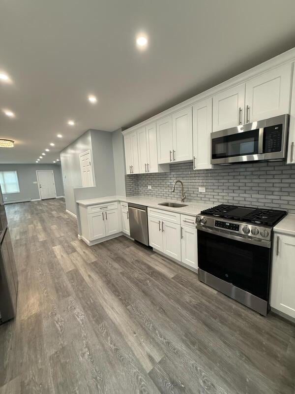 158-04 111th Ave, Jamaica, NY 11433 - kitchen featuring appliances with stainless steel finishes, a sink, light countertops, backsplash, and recessed lighting