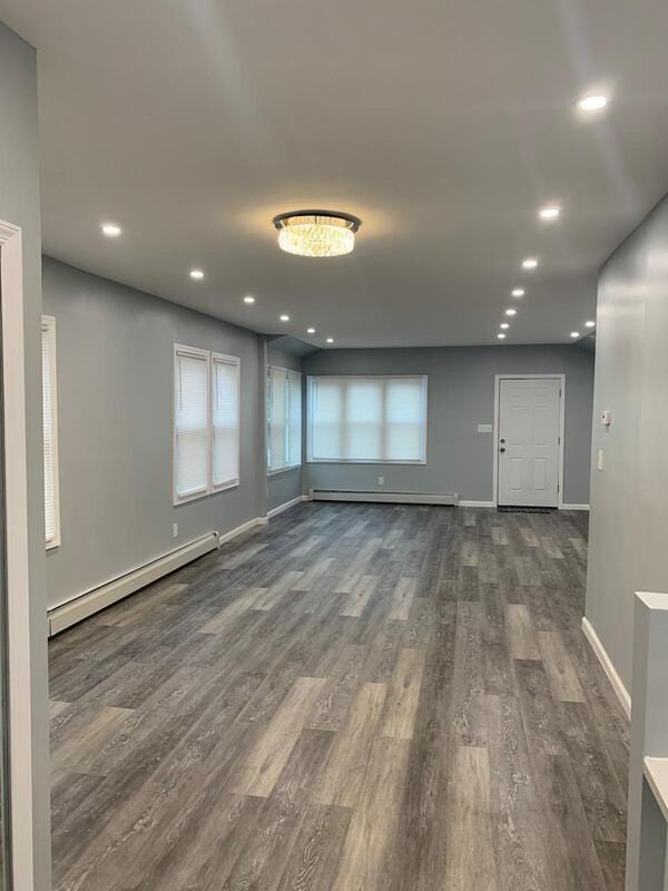 158-04 111th Ave, Jamaica, NY 11433 - spare room featuring a baseboard heating unit, dark wood-style flooring, baseboards, baseboard heating, and recessed lighting